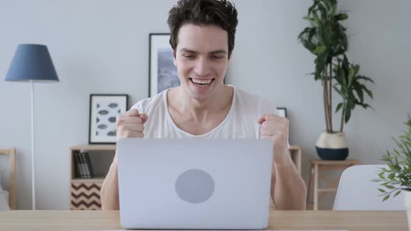 Creative Man Celebrating Successful Results at Work Laptop