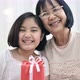 Lovely Asian girl give special gift box to her grand mother. - VideoHive Item for Sale