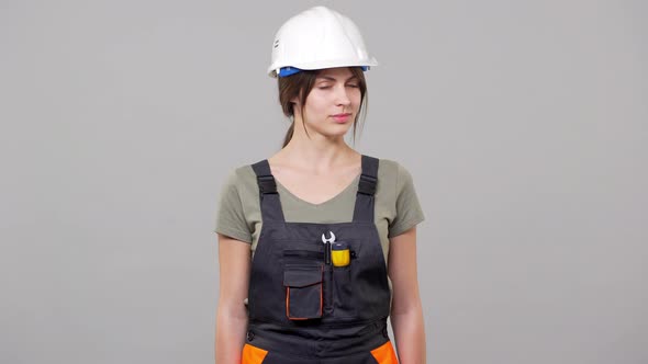 Portrait of European Woman Builder in Helmet and Jumpsuit Shaking Head in Denial While Working on