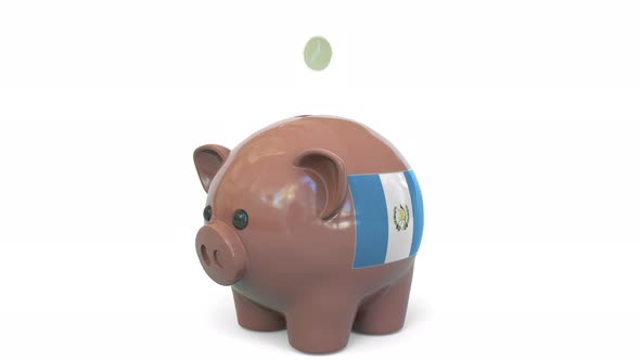 Putting Money Into Piggy Bank with Flag of Guatemala alt