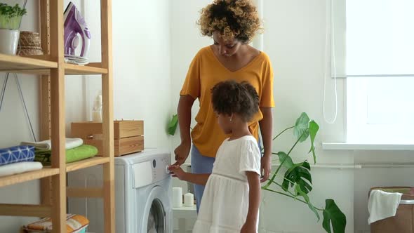 African Mom Teaches Daughter to Start Turn on Washing Machine Spbd