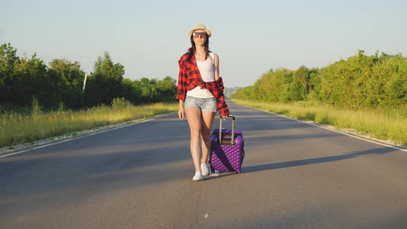 A Sad Woman with Suitcases Run Away Leaving From Home Walks Alone on the Road Without Destination
