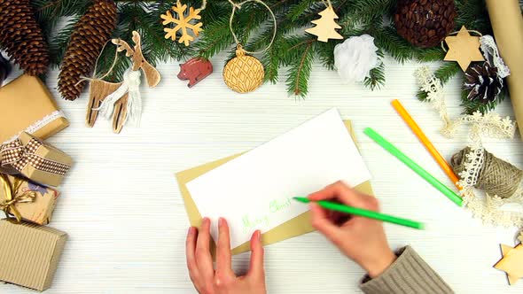 Hands Writing Christmas Greeting Letter