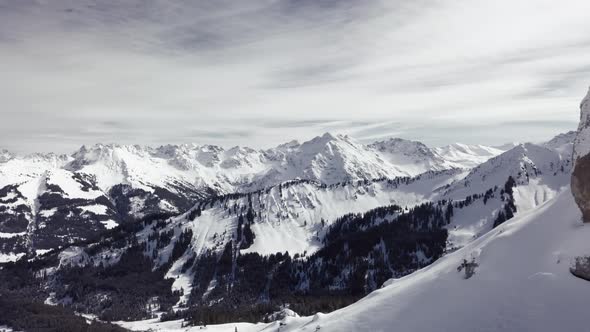 Aerial drone shot on montain rock in the alps, Austria, Kleinwalsertal, skiing area, snowy mountains