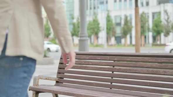 Young Man Coming Sitting on Bench and Checking Time