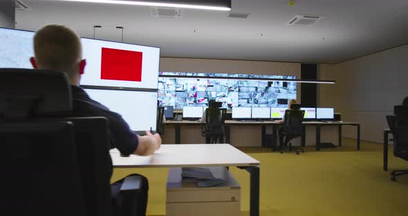 Security Guards Monitoring Modern CCTV Cameras in Surveillance Room