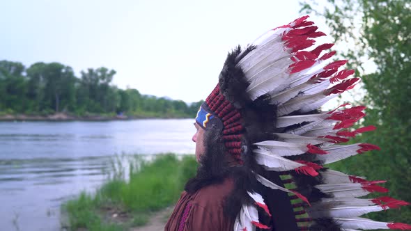 Old Native American Indians Stands on the Background of the River Background of the River
