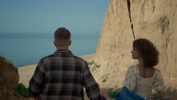 Couple Going Down Coast to Sandy Beach