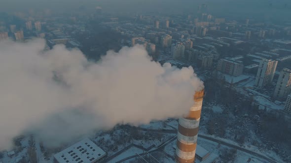 Aerial View of High Chimney Pipes with Grey Smoke with City in the Background