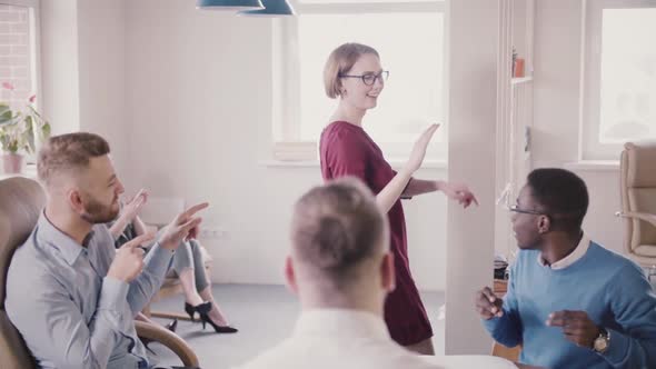 Happy Caucasian Female Boss Doing Victory Dance, Giving High-fives To Multi-ethnic Office Colleagues