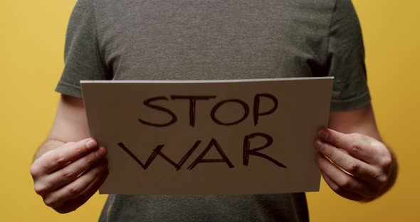 Person holding a white paper with a message Stop War. We Want No War Message.