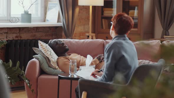 Black Man Lying on Couch and Talking with Psychologist