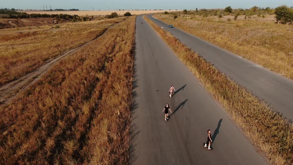 Three Young Ladies Are Longboarding on a Country Road, Landscape, 