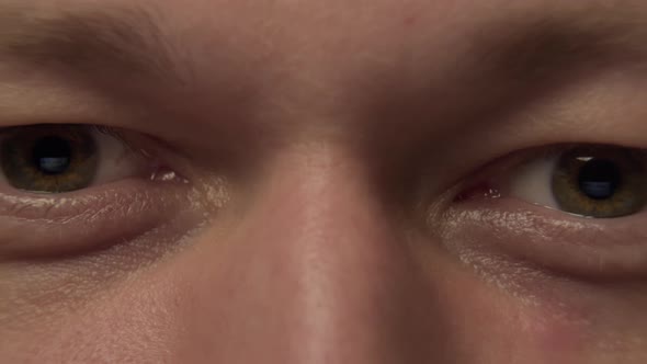 Gray-green eyes of a young man, close-up, camera movement