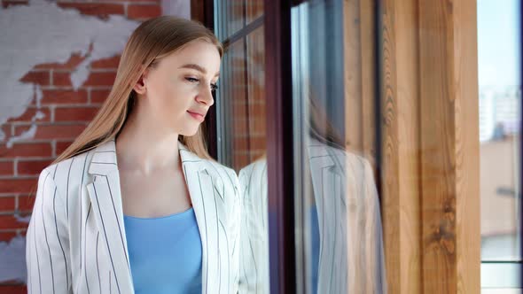 Stylish Young Focused Businesswoman Thinking Looking at Office Window and Dreaming Medium Shot