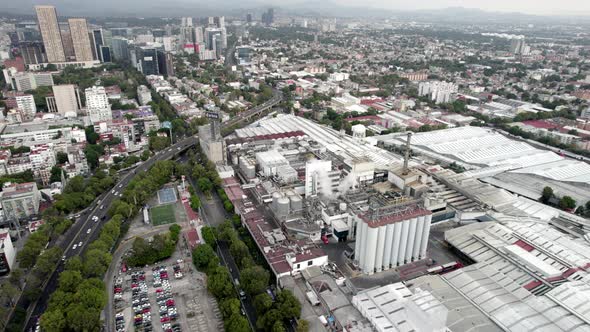 rotational drone shot of a beer factory in the industrial heart of mexico city