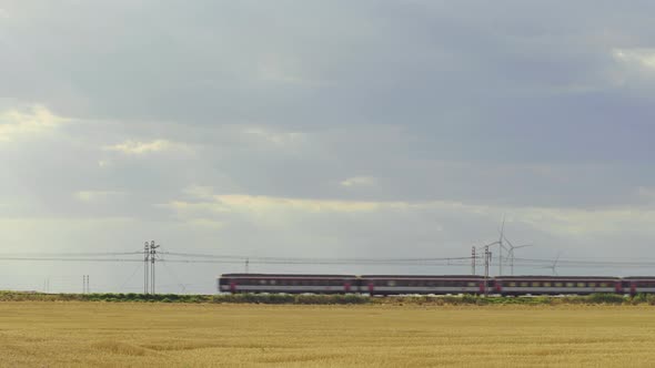 Passing highspeed train in rural summer country landscape.