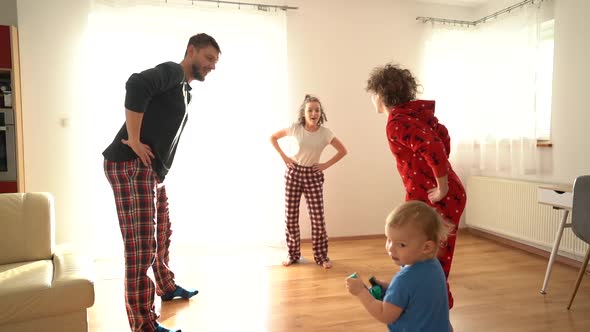 Father and Children Are Doing Exercises in Pajamas