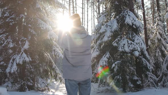 Young Woman Plays with the Rays of the Sun in a Winter Forest Woman Enjoying the Winter Time During