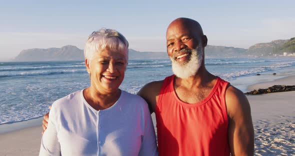 Portrait of senior african american couple embracing and smiling at the beach