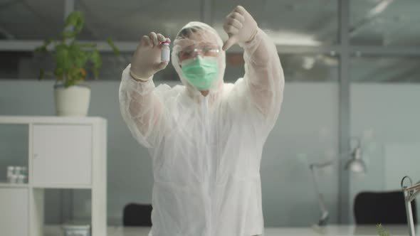 A Medic a Man in a Protective Suit Shows a Bottle of Medicine and Urges Not to Use It Slowmotion