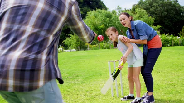 Happy family playing cricket