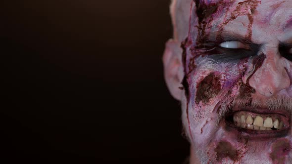 Frightening Man Face with Halloween Zombie Bloody Wounded Makeup Blood Flows and Drips on Face