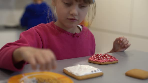 Girl Decorates Homemade Gingerbread for Easter