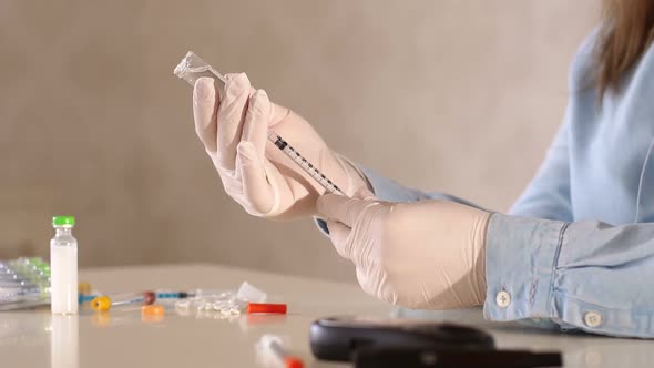 A Girl in Gloves is Picking Up Shortacting Insulin in an Insulin Syringe