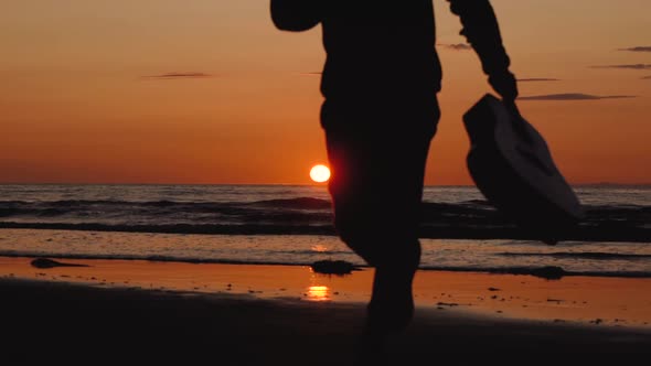 Man running with guitar in back sand beach at sunset. Beautiful, moody shots from the Sony a7iii.