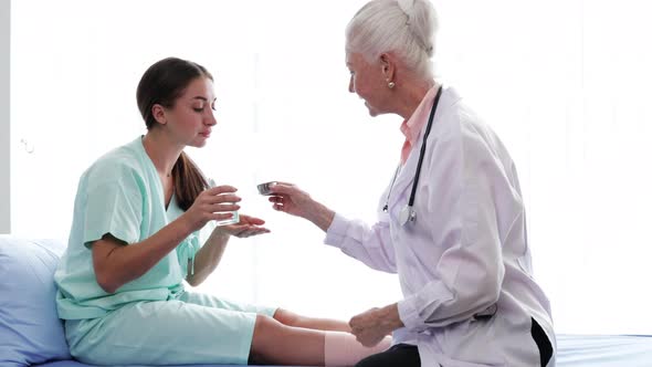 Senior Female doctor checking the symptoms of the woman patient.