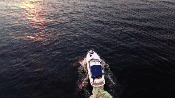 Scenic Aerial Yacht Following Shot During Sunset with Red and Orange Sky Above Reflecting River