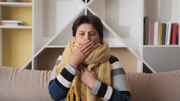 Woman with a Cold Sneezes at Home