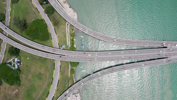 Aerial top view of Penang Bridge start of highway with light traffic from island side, drone dolly r