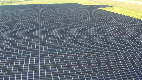 Top view of the power plant with solar panels. Beautiful green fields.