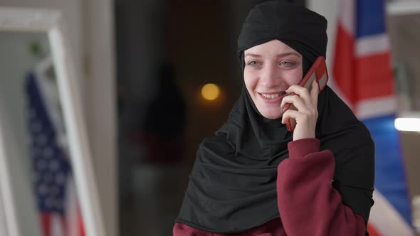 Positive Caucasian Woman in Hijab Talking on the Phone Smiling