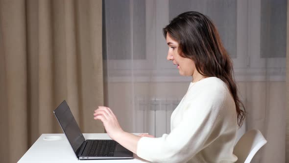 Skilled Freelancer with Long Loose Hair Opens Laptop in Room