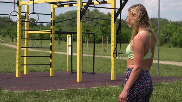 A Fit Beautiful Woman Looks Around at an Outdoor Gym