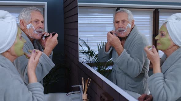 Old Senior Couple Man and Woman Doing Morning Hygiene Procedures and Looking Into a Mirror
