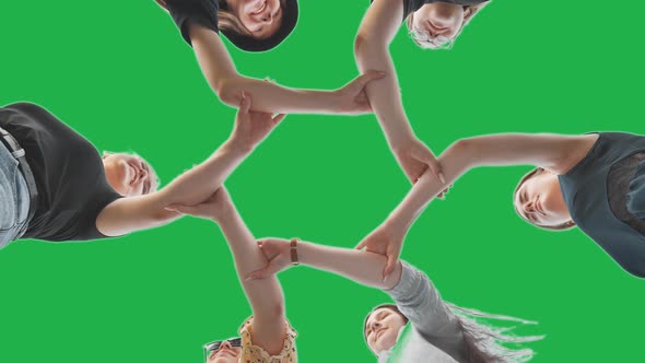 Friends Join Their Wrists and Make a Circle on a Green Background