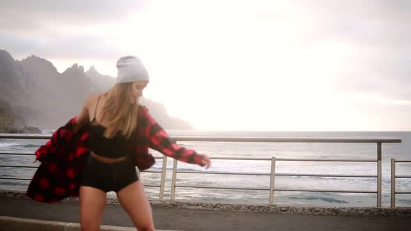 Sport Lifestyle Extreme and People Concept Beautiful Girl Riding Longboard By the Coastline Road in