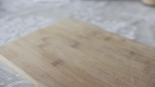 Man's Hand Puts Pepper on the Cutting Board