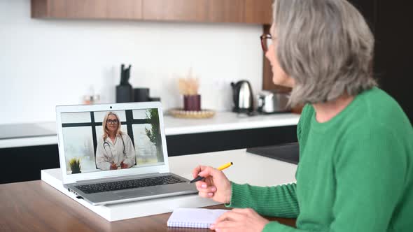 Mature Senior Woman Is Using a Laptop for Video Call at Home