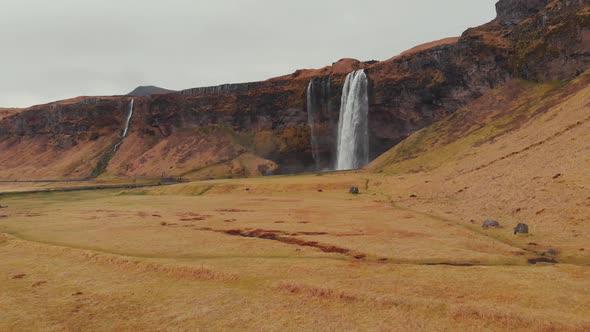 Panorama of dry field with waterfall