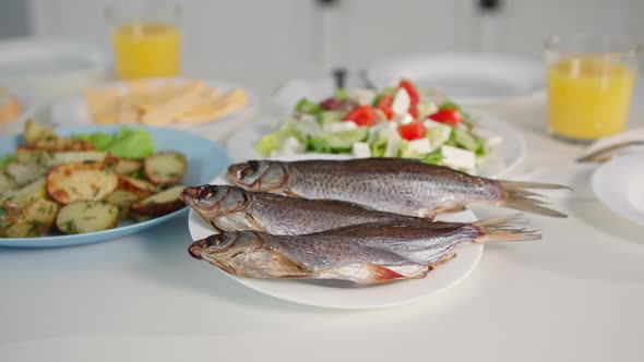 Seafood Delicious Fresh Fish on a Plate Near Salad and Fried Potatoes on the Table Closeup