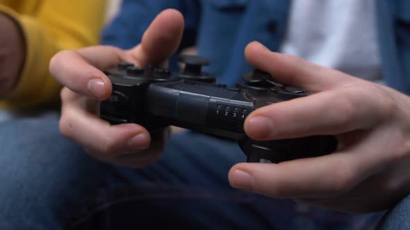 Two Young Males Playing Video Games, Hands Pushing Joystick Buttons, Closeup