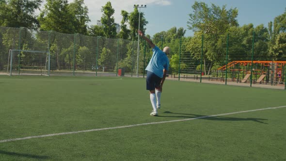 Soccer Player Helping to Relieve Cramping to Teammate on Football Pitch