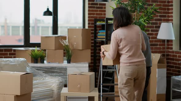 Married Couple Unpacking Furniture and Decor in New Household