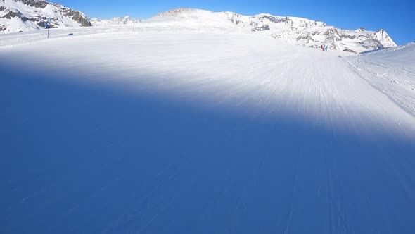 A Snowboarder Descends at Speed From a Mountainside in the Alps