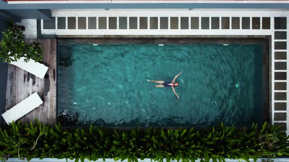 Woman Lay on the Water in the Pool Top Down